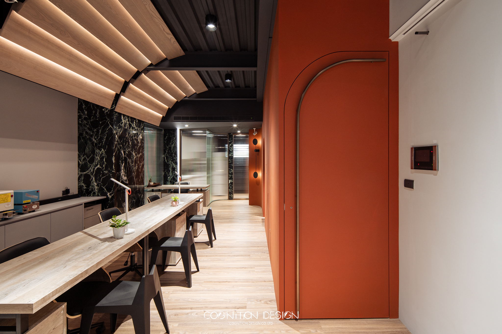 店面設計一樓隱藏樓梯設計，採用橘紅色牆面搭配金屬質感門把