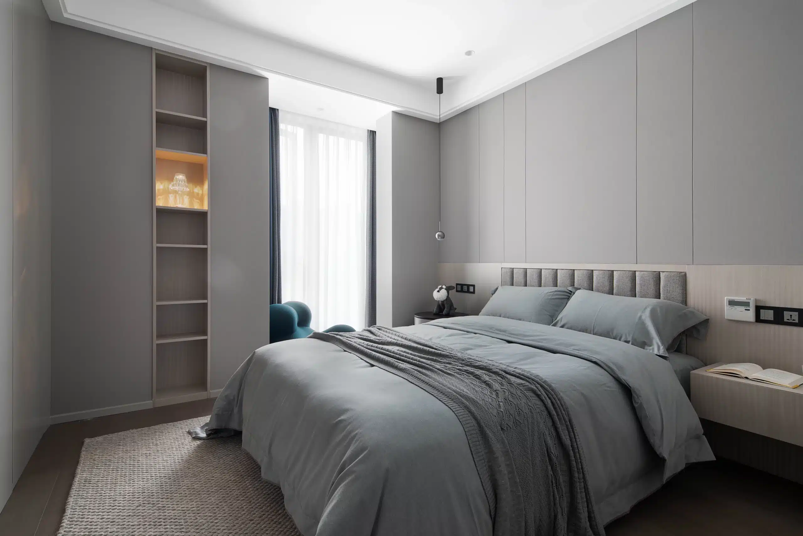現代簡約風小坪數臥室設計，低矮床架搭配無把手系統櫃，灰白色中性配色展現俐落線條，視覺放大有限坪數