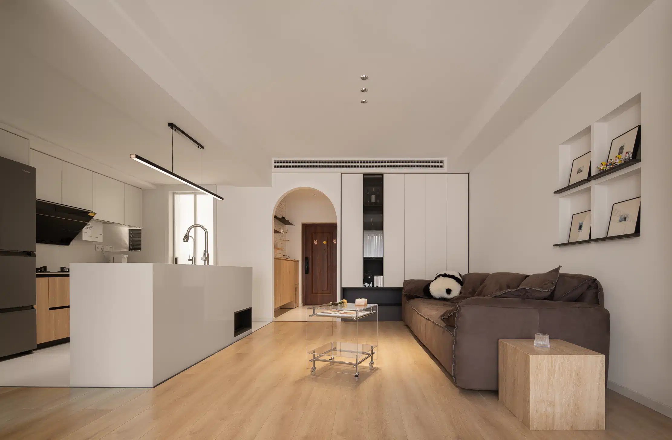 長型空間色彩與燈光佈局,利用淺色系牆面與間接照明放大視覺感受。