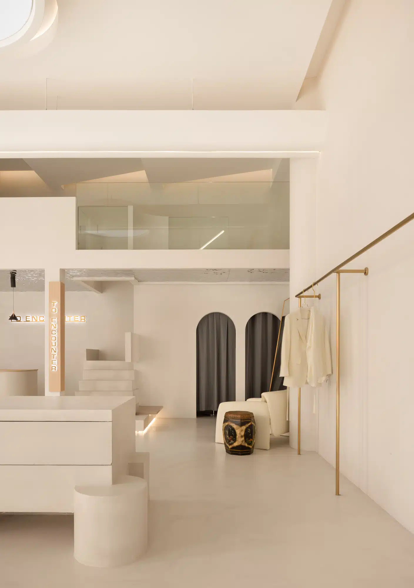 韓系奶油極簡風格服飾店裝潢,使用米色藝術塗料與圓弧拱門設計。