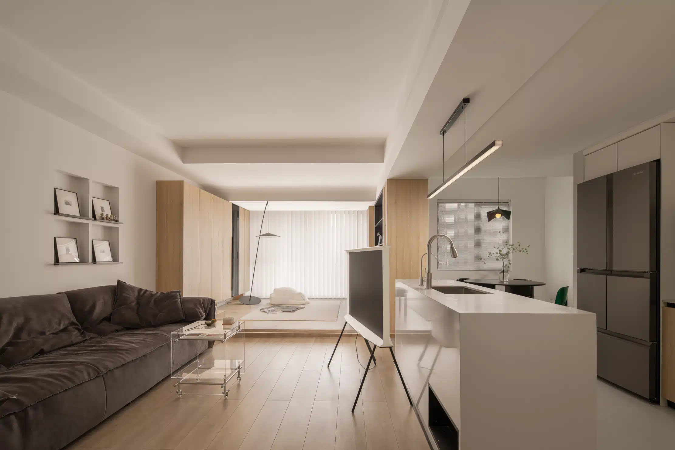 長型客廳分區規劃實景,利用中島為隱形隔間,劃分客廳與開放式廚房。